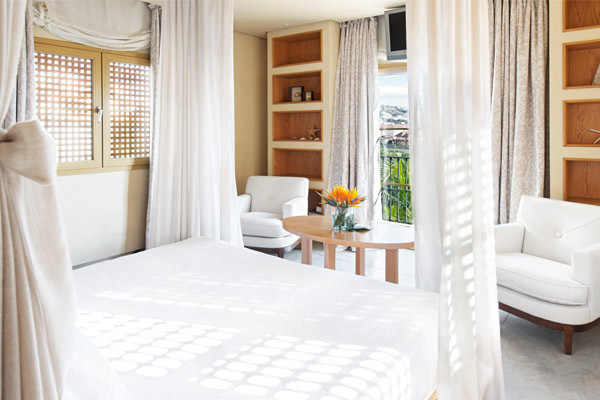 Das Zimmer verwöhnt mit sanften Naturtönen, viel Tageslicht und einem Balkon mit Blick auf Palmen und Meer